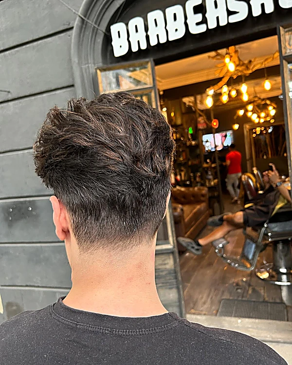 Corte con textura arriba y degradado en la nuca, visto de espaldas